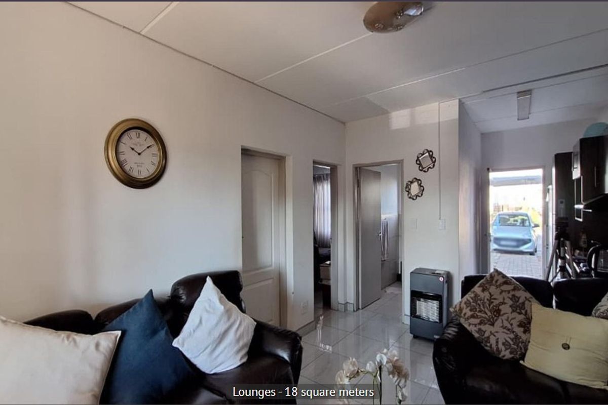 A living room area featuring tiled flooring and access to adjacent rooms, providing a functional space for relaxation.