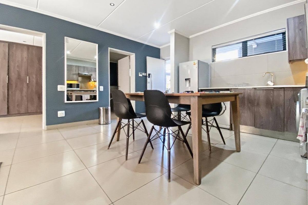 Open-plan living and kitchen area featuring modern tiled flooring, built-in cabinetry, and a functional layout suitable for dining and daily living.
