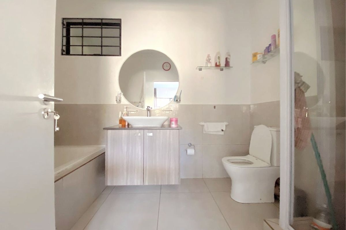 A functional bathroom featuring a vanity with a vessel sink, a bathtub, a separate shower enclosure, and a toilet.