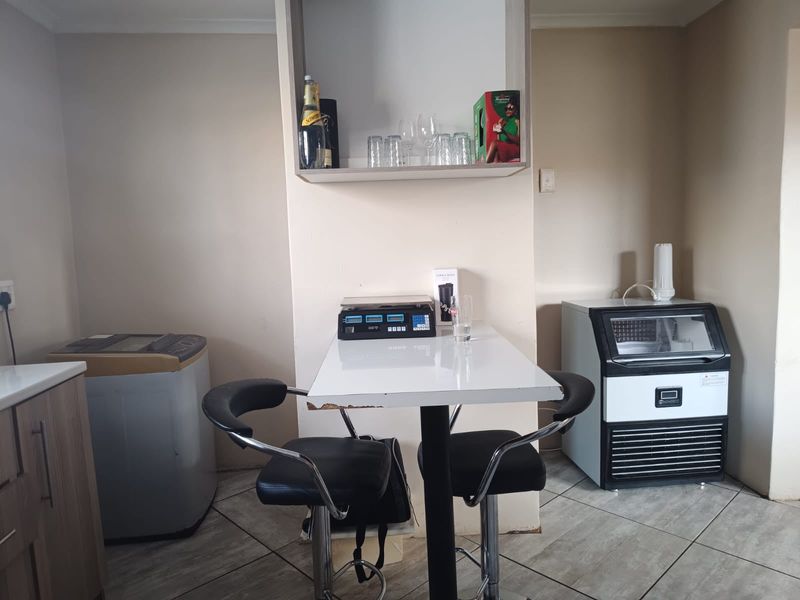A functional utility space featuring tiled flooring and built-in shelving, suitable for a laundry or prep area.