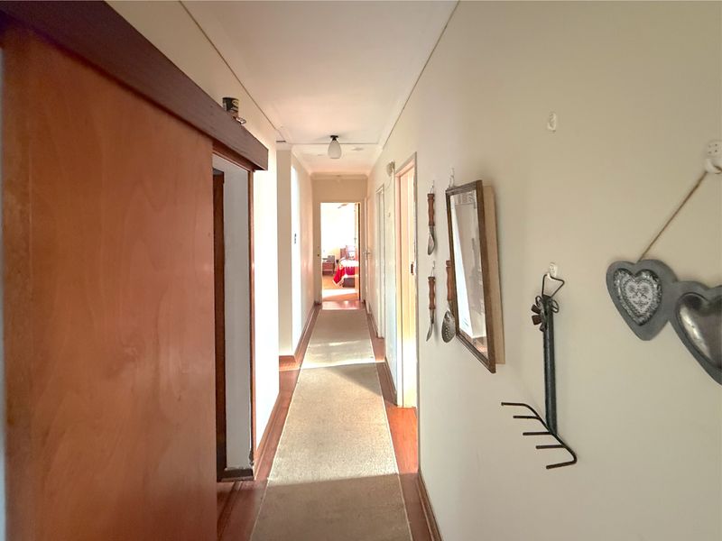 A functional hallway connecting multiple rooms, featuring wooden door frames and neutral wall finishes.