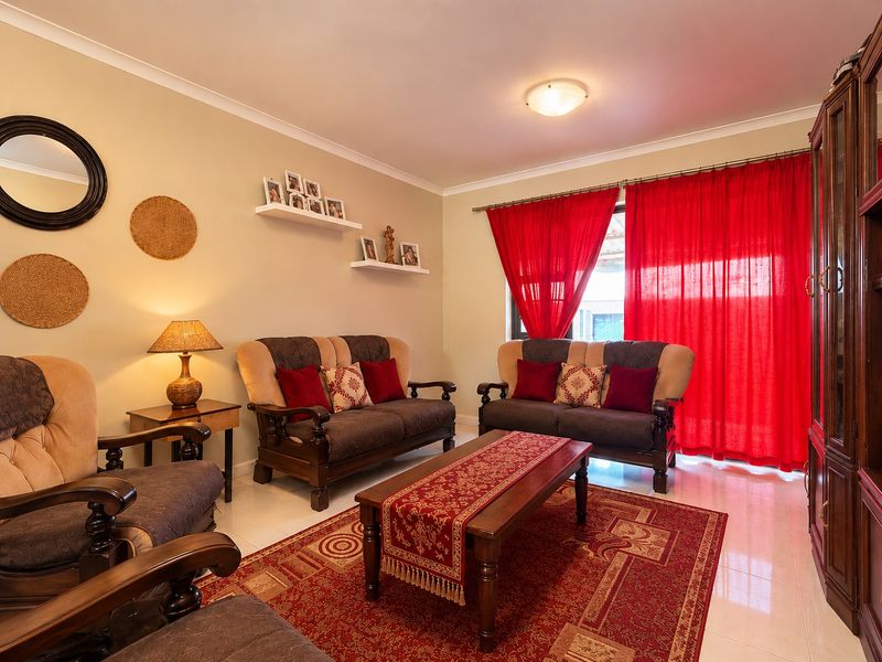 A comfortable living room featuring tiled flooring and neutral wall tones, providing a functional space for relaxation and family gatherings.