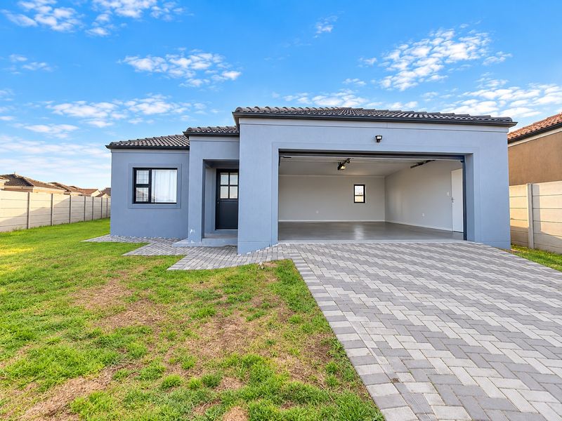 Modern single-story home featuring a paved driveway, double garage, and well-maintained exterior facade with a neat lawn.