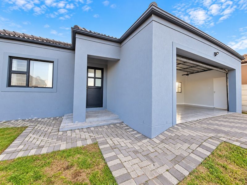 Modern front elevation featuring a paved driveway, integrated garage, and clean, contemporary architectural lines with a well-maintained exterior finish.