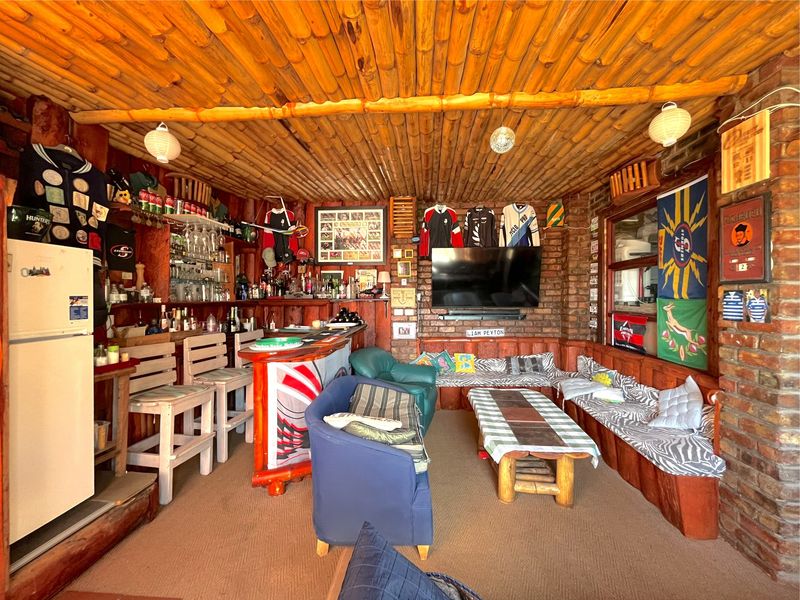A rustic-style entertainment bar featuring exposed brick walls, a unique bamboo ceiling, and built-in bench seating, creating a cozy atmosphere for social gatherings.