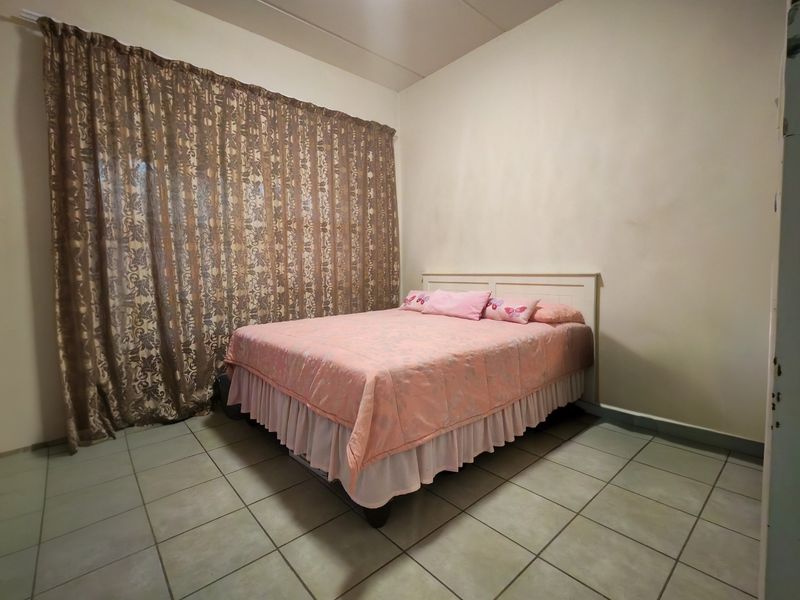 A bedroom featuring tiled flooring and neutral wall finishes, providing a functional space ready for personalization.
