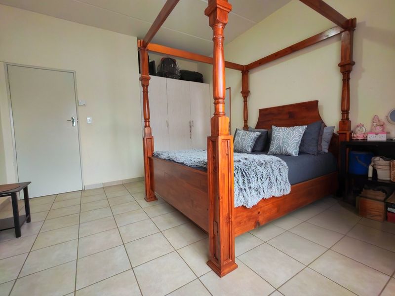 A bedroom featuring tiled flooring and a built-in wardrobe, providing a functional space with neutral wall finishes.