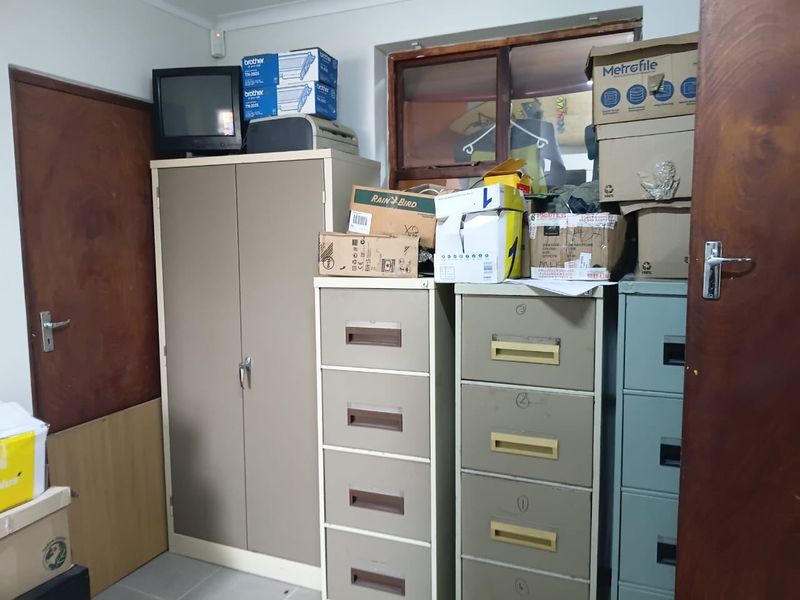A utility or storage room featuring multiple metal filing cabinets and storage cupboards, currently used for document and equipment storage.