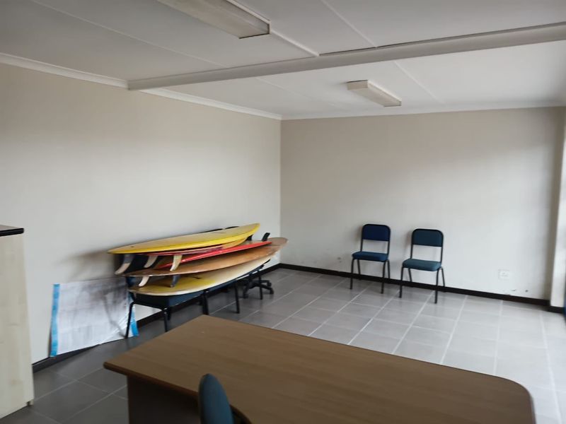 A functional office space featuring neutral walls, tiled flooring, and overhead fluorescent lighting, suitable for a variety of commercial business applications.