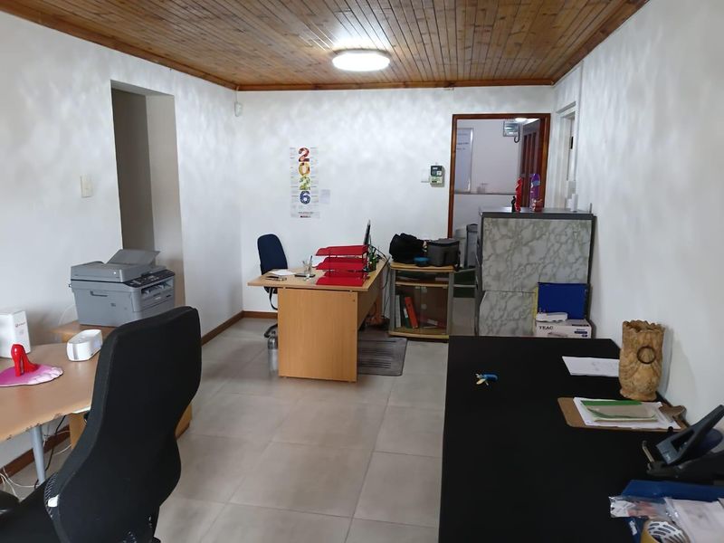 A functional office space featuring ceramic floor tiles and a timber tongue and groove ceiling, suitable for a professional commercial work environment.