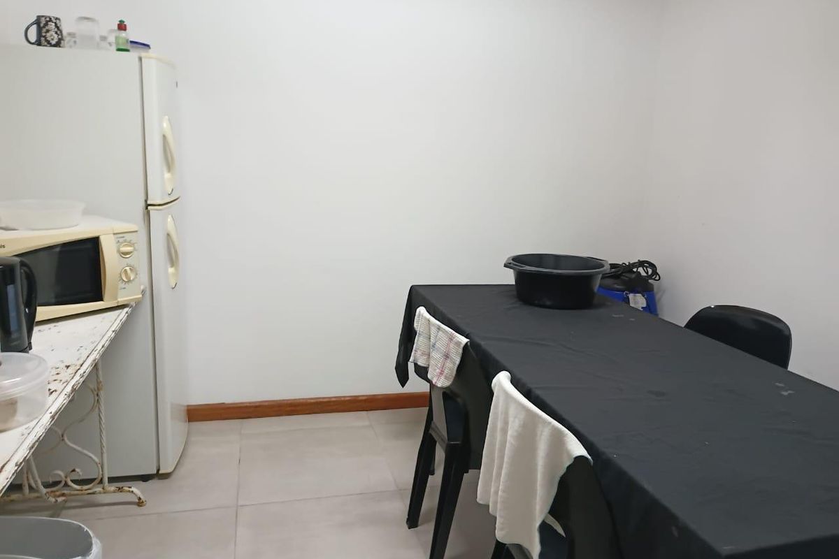 A basic kitchen area featuring tiled flooring and simple wall finishes, suitable for functional use or potential renovation.