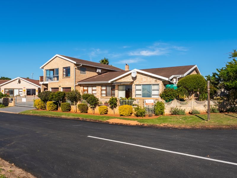 A well-maintained face brick residential property featuring a tiled roof, secure boundary wall, and paved driveway, situated in a quiet street setting.
