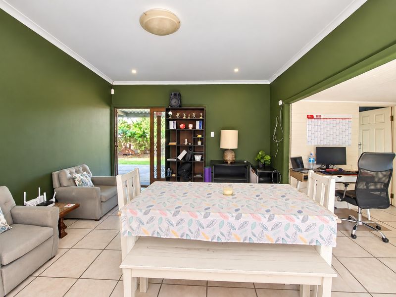 Spacious open-plan living and dining area featuring tiled flooring, recessed lighting, and direct access to the outdoor patio through a sliding glass door.