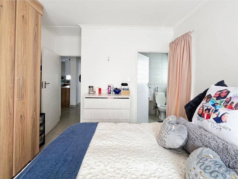 A bedroom featuring a built-in wardrobe and direct access to an en-suite bathroom with tiled finishes.