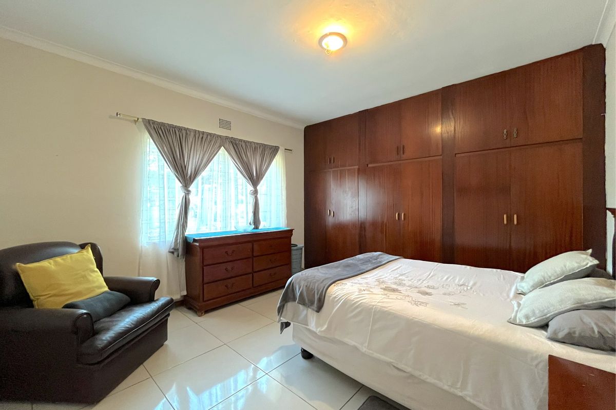 A bedroom featuring tiled flooring and extensive built-in wooden cabinetry for storage.
