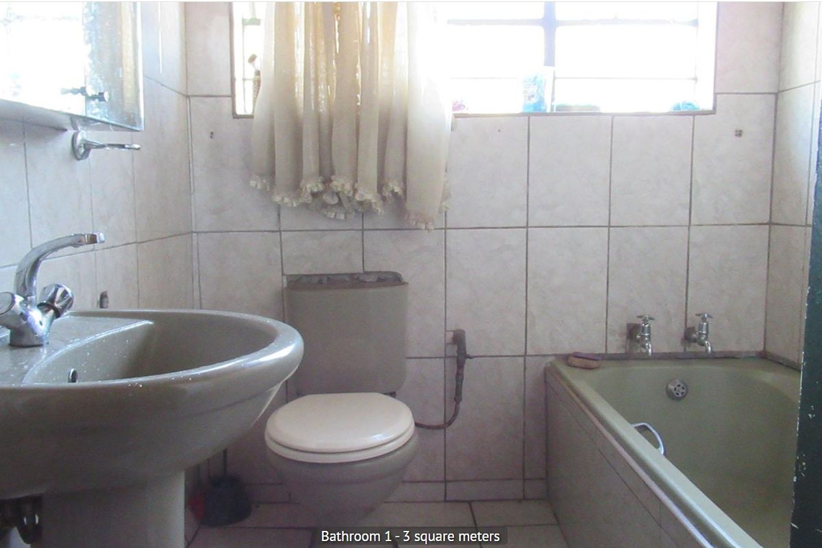 A compact bathroom featuring a pedestal basin, toilet, and bathtub with dated finishes, requiring modernization to improve functionality and aesthetic appeal.