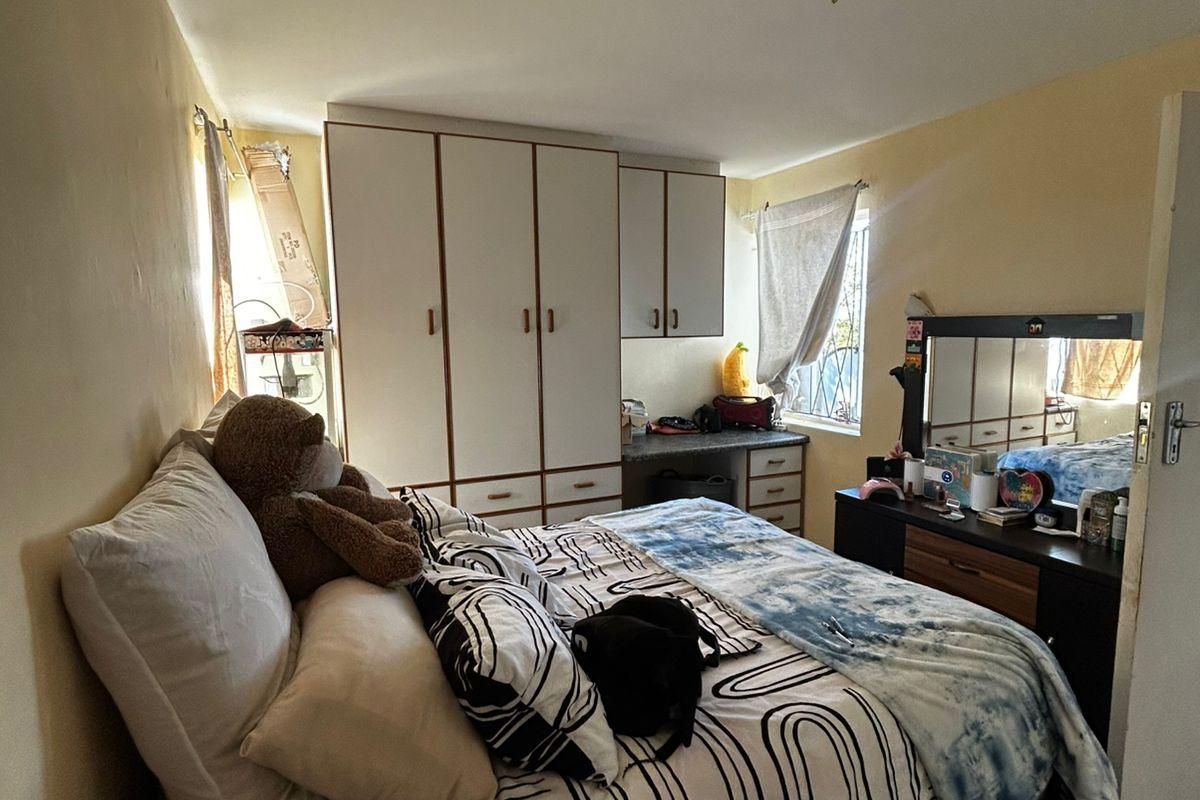 A bedroom featuring built-in cabinetry with integrated desk space and tiled flooring.