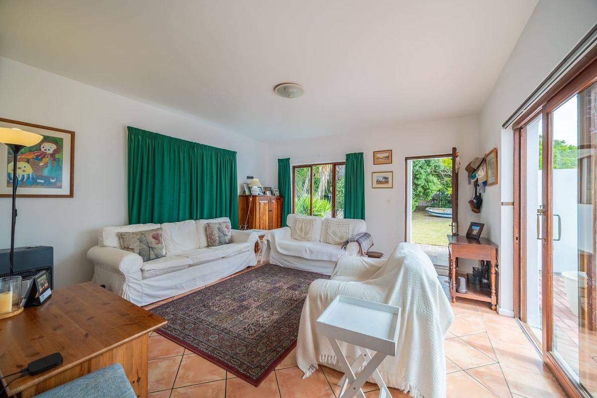 A bright living room featuring terracotta floor tiles and sliding glass doors that provide direct access to the rear garden.