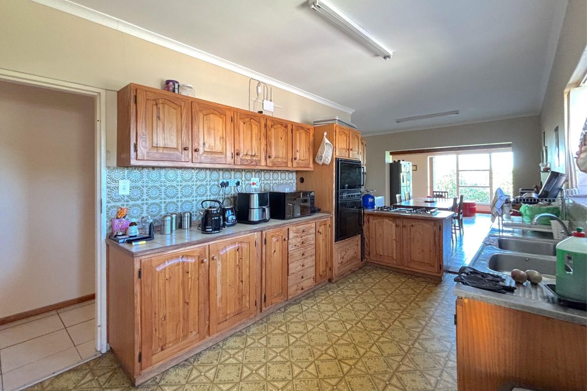 Spacious kitchen featuring traditional timber cabinetry, built-in oven, and a functional layout that flows into the adjacent dining area.