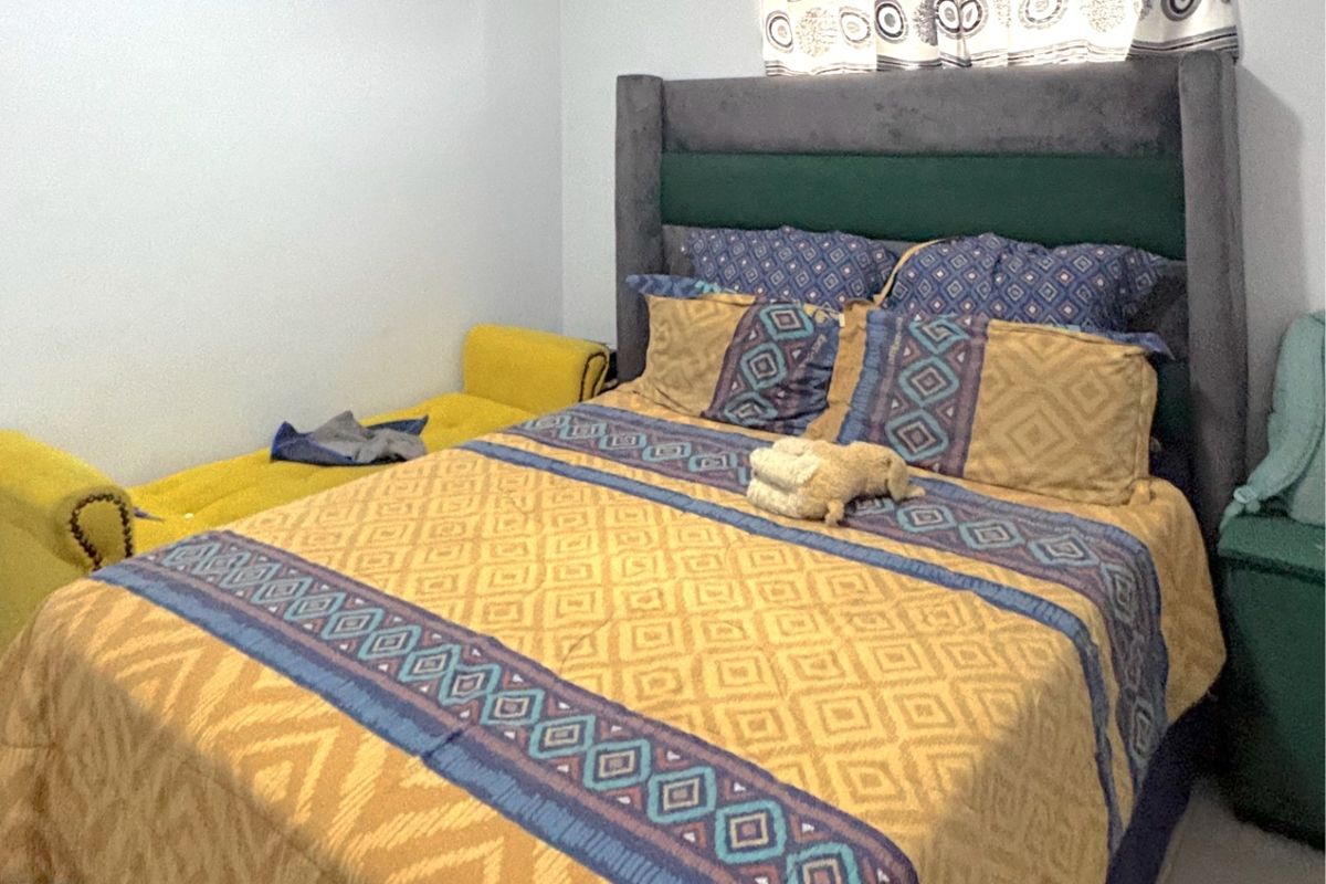 A bedroom featuring tiled flooring and a window with a curtain rod.