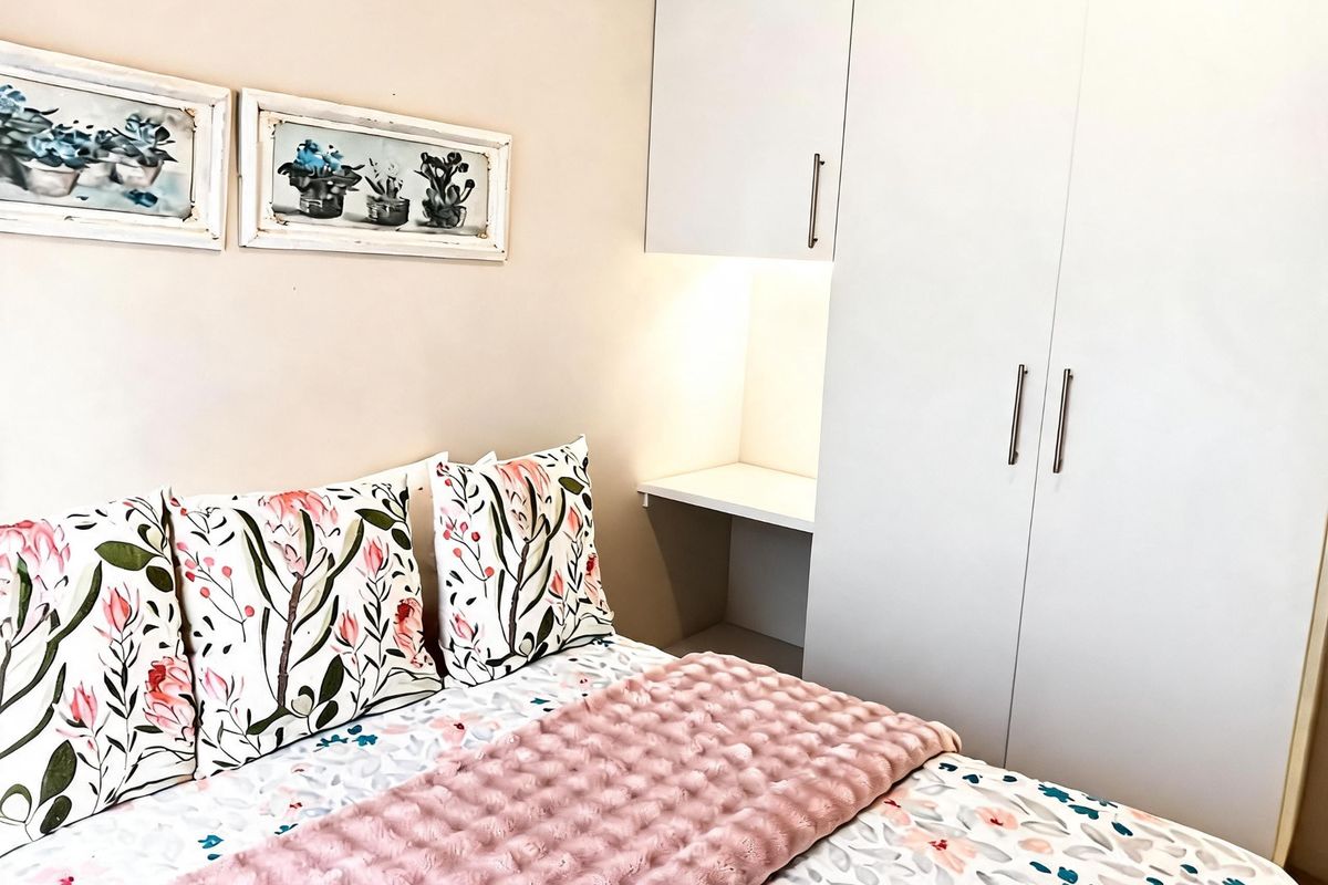 A well-maintained bedroom featuring built-in white cabinetry with integrated shelving and under-cabinet lighting.