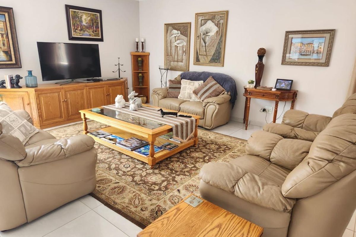 A comfortable living room featuring tiled flooring and neutral wall finishes, providing a functional and inviting space for relaxation.