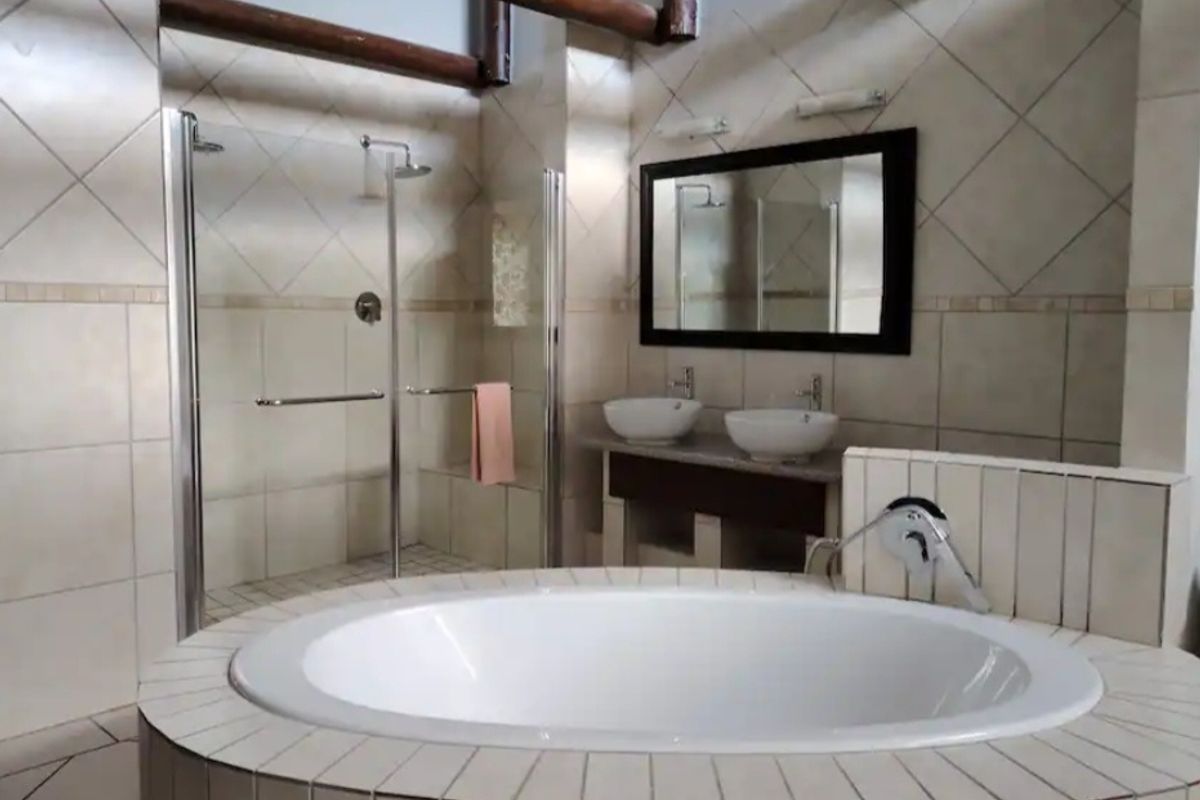 Spacious bathroom featuring a built-in circular bathtub, double vanity with vessel sinks, and a separate walk-in shower with glass enclosure.