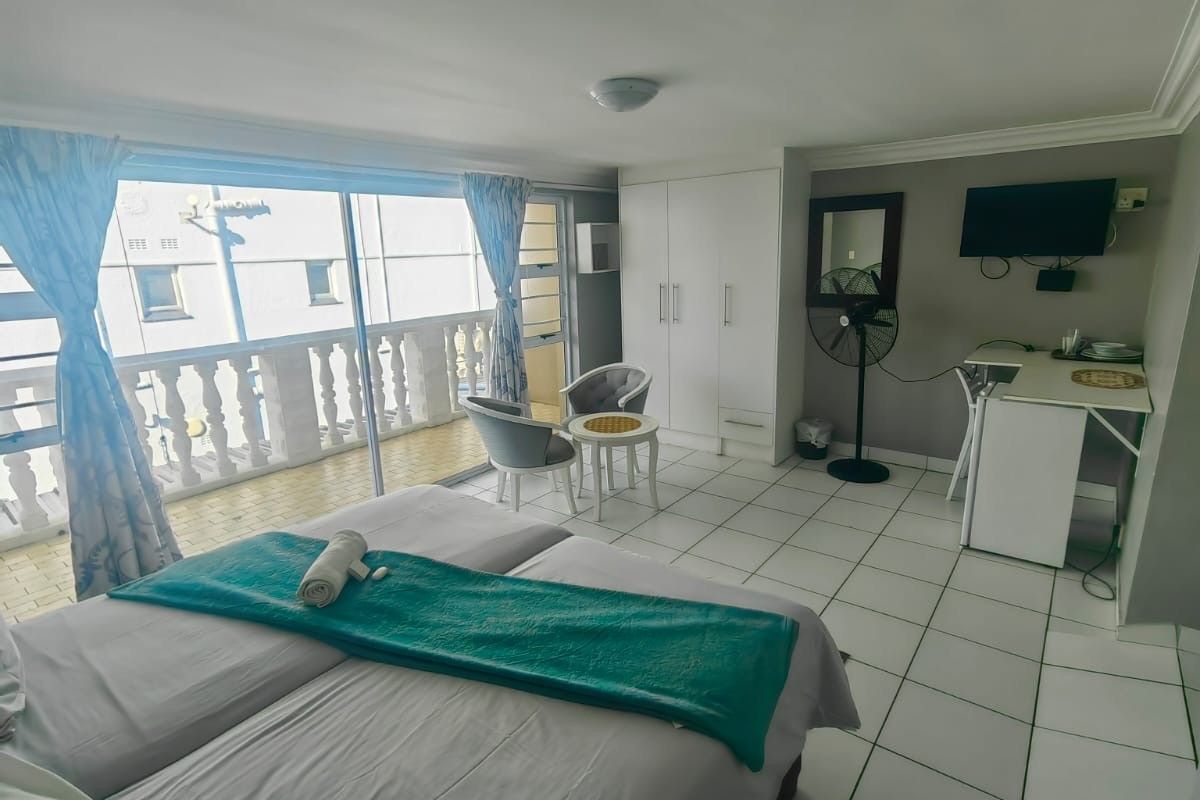 A bedroom featuring ceramic floor tiles, built-in wardrobe, and a sliding glass door leading to a balcony.