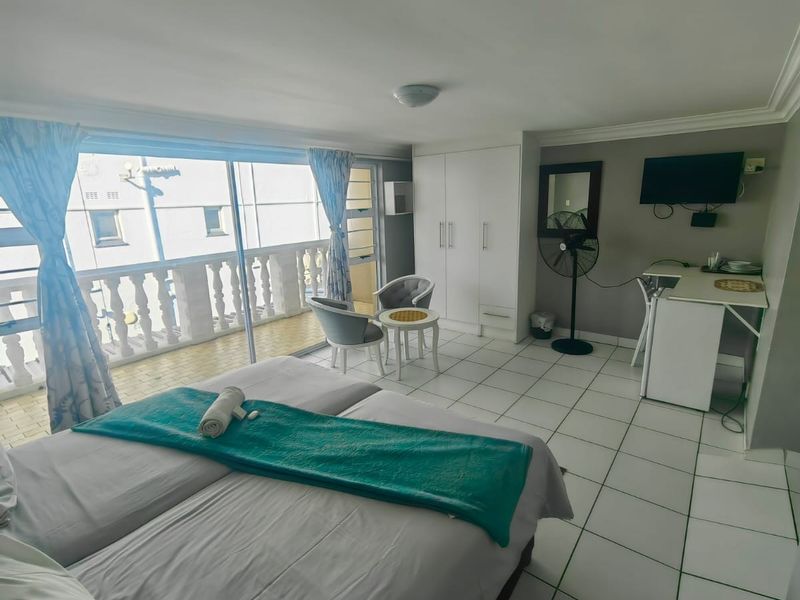A bedroom featuring ceramic floor tiles, built-in wardrobe, and a sliding glass door leading to a balcony.