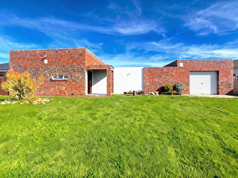Front view of a single-story face brick house featuring a single garage, covered entrance, and a well-maintained front lawn.