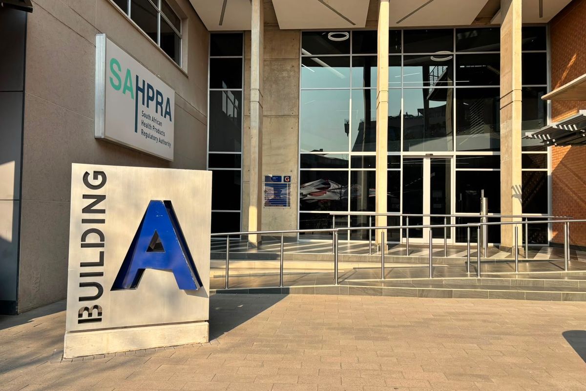 Modern commercial building entrance featuring a glass facade, concrete structural pillars, and professional signage for Building A.