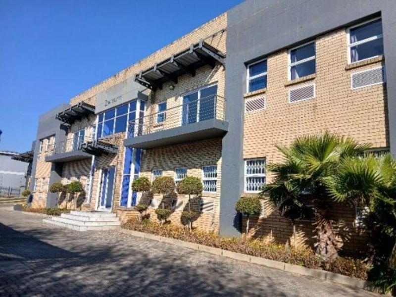 Modern industrial office building featuring a face brick facade, glass curtain walling, and integrated balconies with metal awnings.