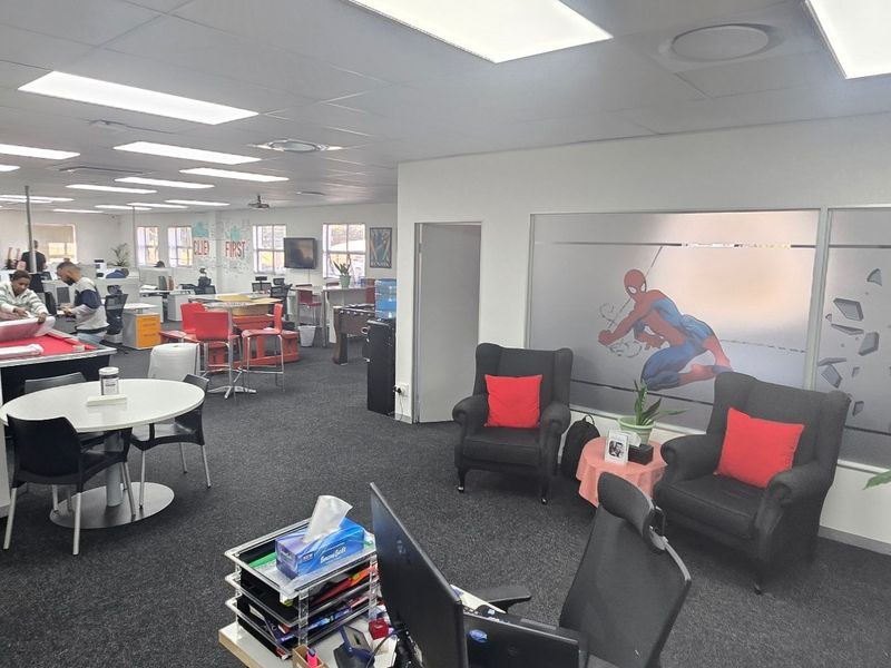Spacious open-plan commercial office area featuring recessed lighting, carpeted flooring, and frosted glass partitions, providing a versatile and functional workspace environment.