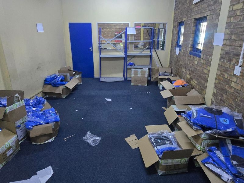 A functional utility or storage space featuring exposed brickwork, carpeted flooring, and an internal window, suitable for various industrial or commercial storage applications.