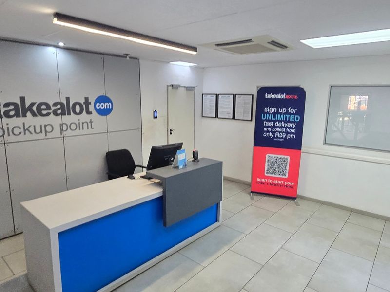 A functional industrial reception area featuring a built-in service counter, tiled flooring, and recessed ceiling lighting.