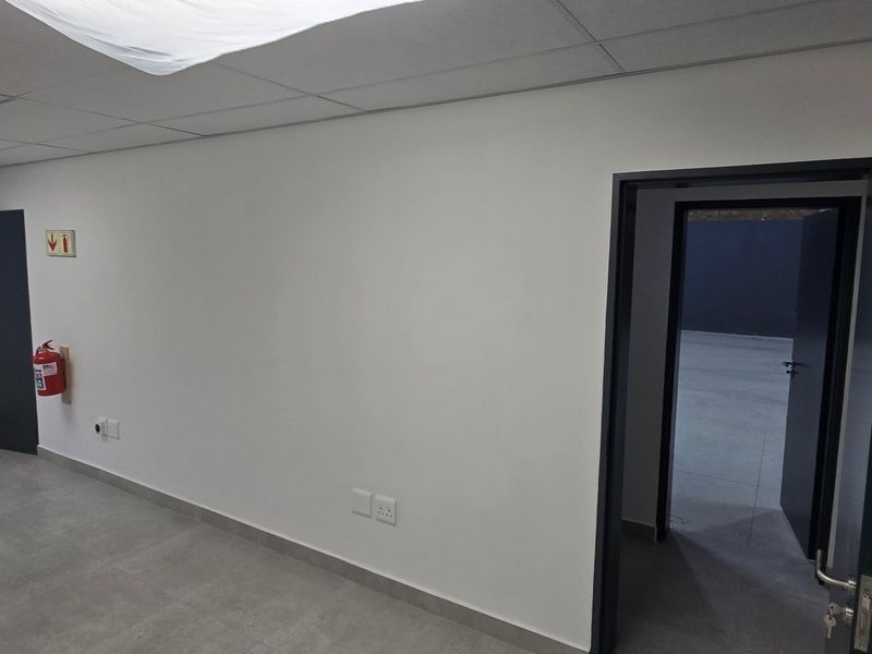 A clean, empty office space featuring tiled flooring, a suspended ceiling, and neutral walls, providing a versatile environment for industrial or commercial use.