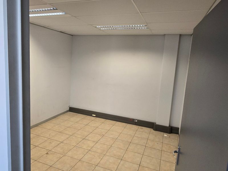 A vacant office space featuring ceramic tiled flooring, a suspended ceiling with recessed lighting, and perimeter electrical trunking.