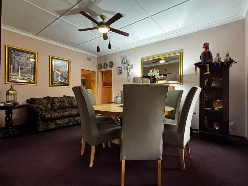 A dining room featuring a ceiling fan and tiled ceiling, providing a functional space for meals.