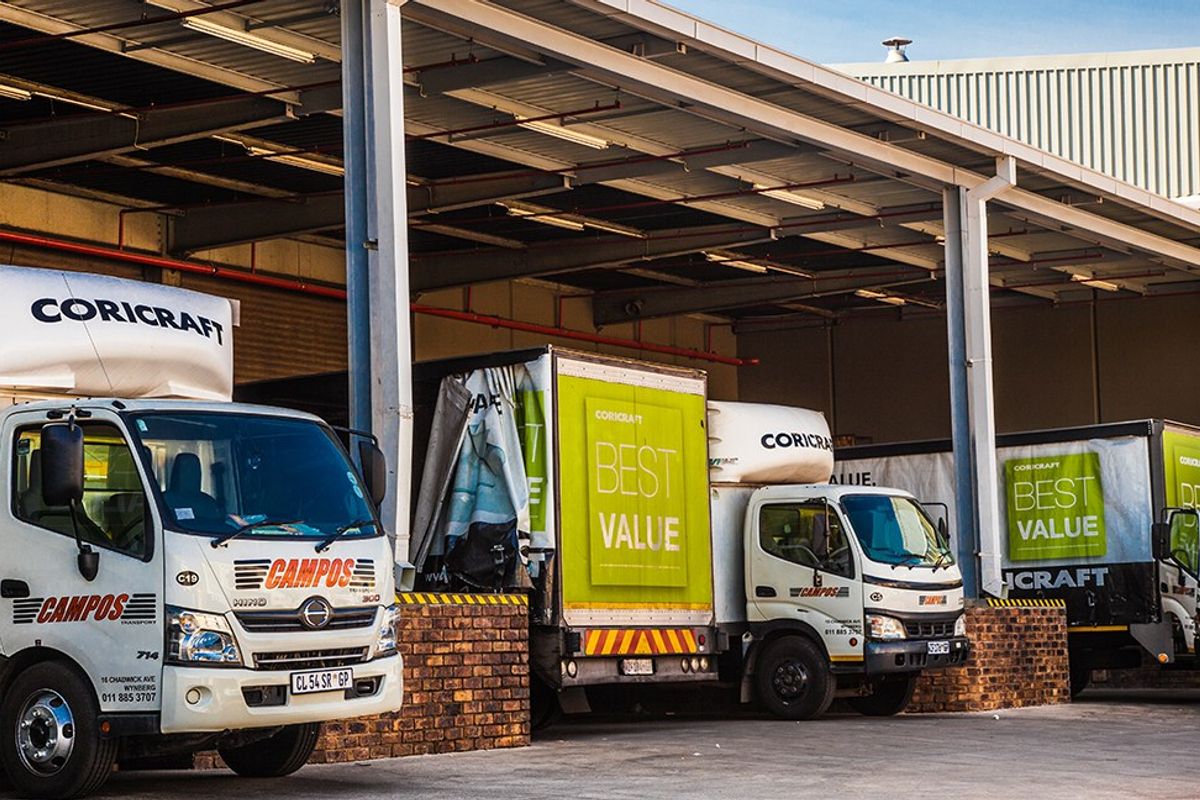 Industrial loading bay area featuring a steel portal frame structure with corrugated metal roofing and a brick-faced loading platform.