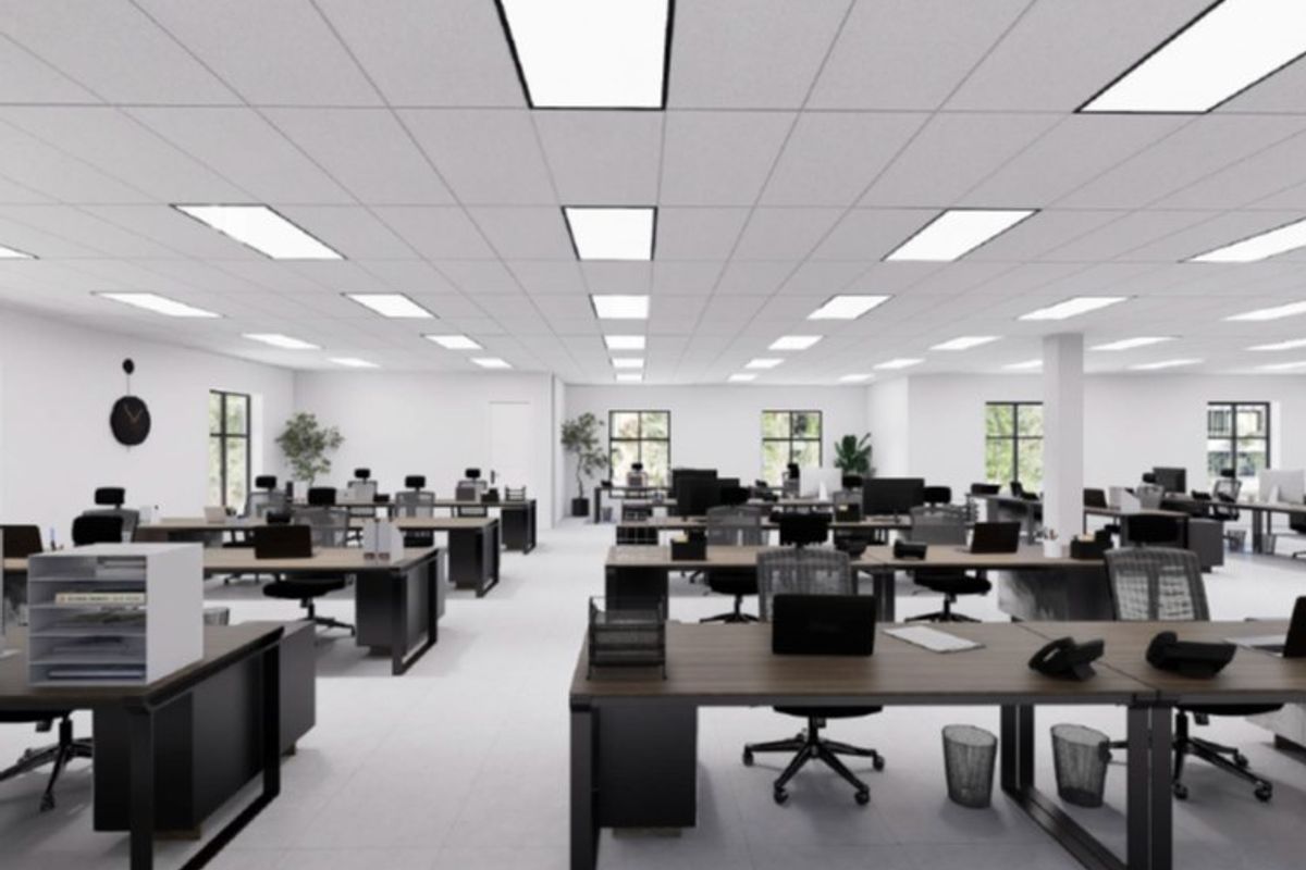 A modern, open-plan commercial office space featuring a suspended ceiling with recessed lighting panels and clean, tiled flooring.