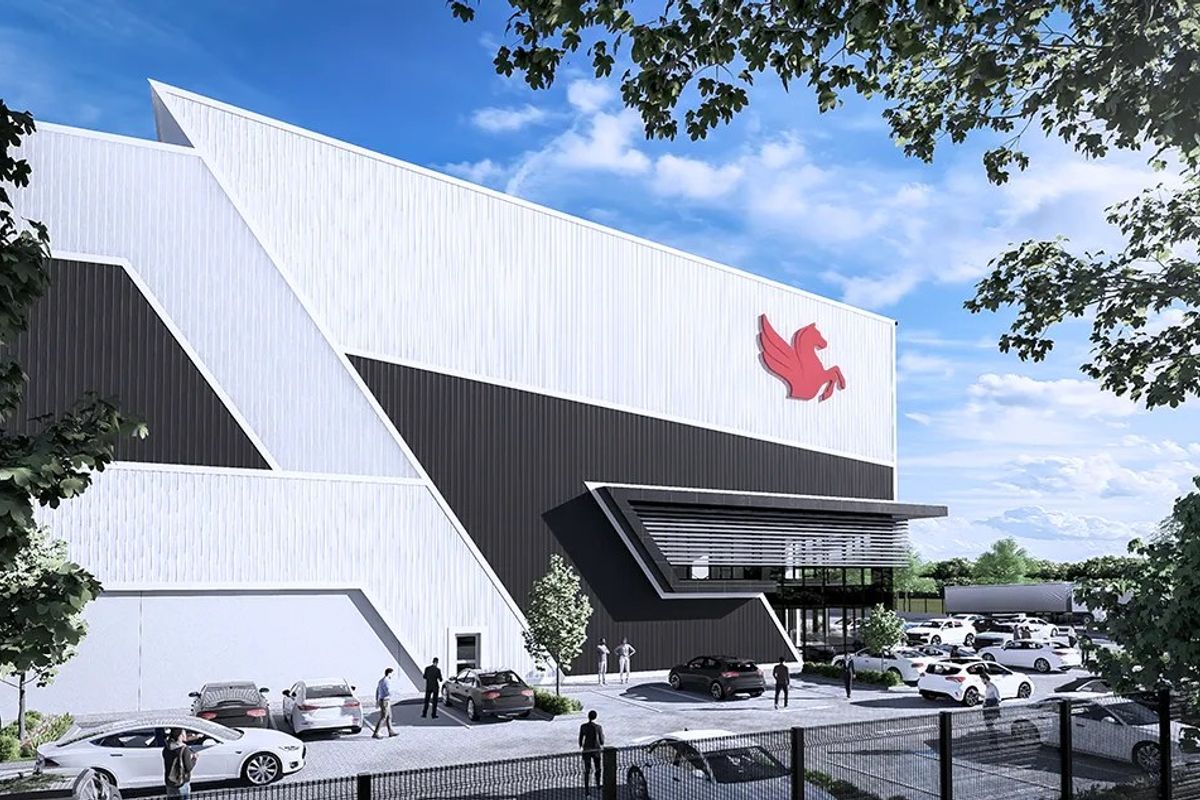 Modern industrial facility featuring a striking geometric facade with metal cladding, integrated canopy, and ample on-site parking.