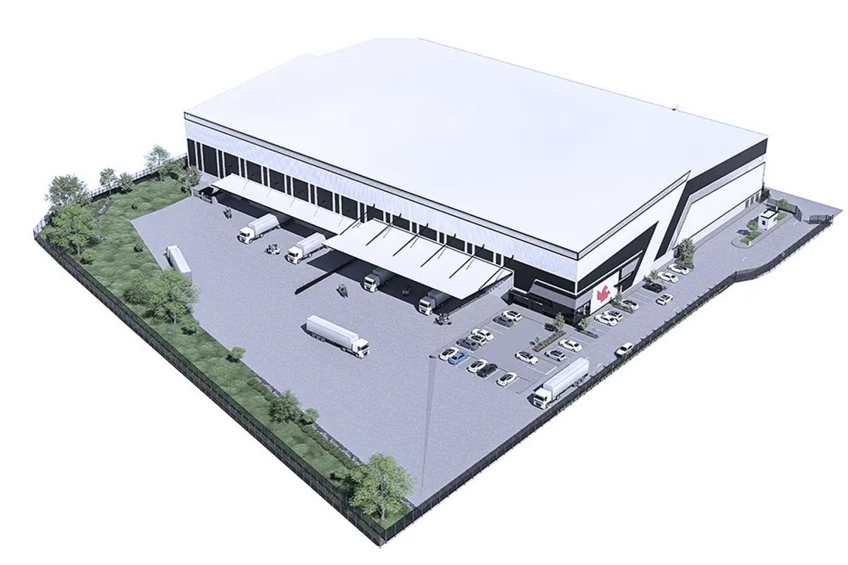 An aerial perspective of a modern industrial warehouse facility featuring a large paved yard, loading docks with canopies, and secure perimeter fencing.