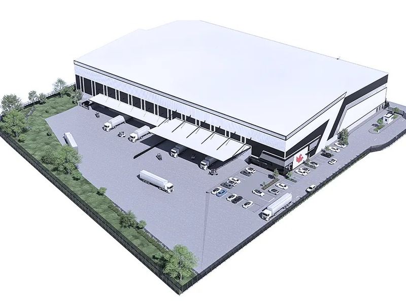 An aerial perspective of a modern industrial warehouse facility featuring a large paved yard, loading docks with canopies, and secure perimeter fencing.