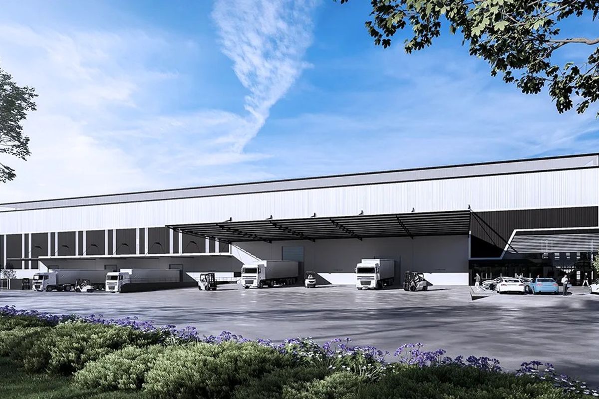 Modern industrial warehouse facility featuring a large concrete loading yard, multiple loading docks, and an expansive protective canopy for logistics operations.