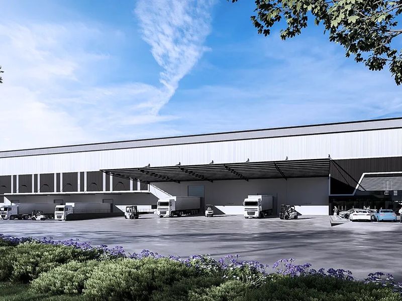 Modern industrial warehouse facility featuring a large concrete loading yard, multiple loading docks, and an expansive protective canopy for logistics operations.