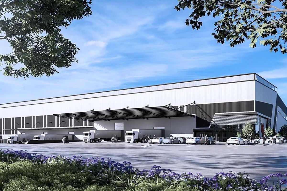 Modern industrial warehouse facility featuring a large loading canopy, expansive asphalt yard, and contemporary metal cladding exterior.