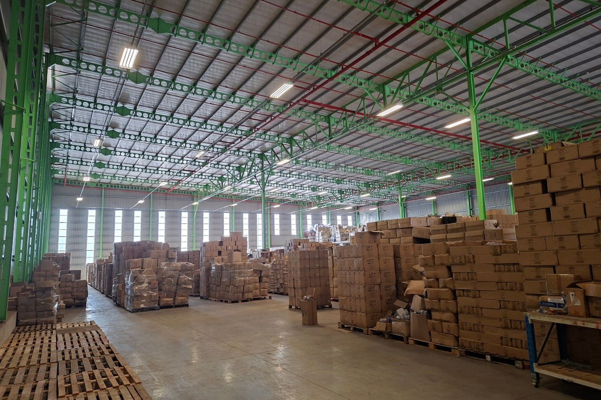 Spacious industrial warehouse featuring high-clearance steel truss roofing, integrated sprinkler system, polished concrete flooring, and ample natural light through high-level windows.