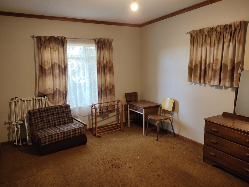 A bedroom featuring timber crown molding and carpet flooring, offering a blank canvas for renovation and modernization.