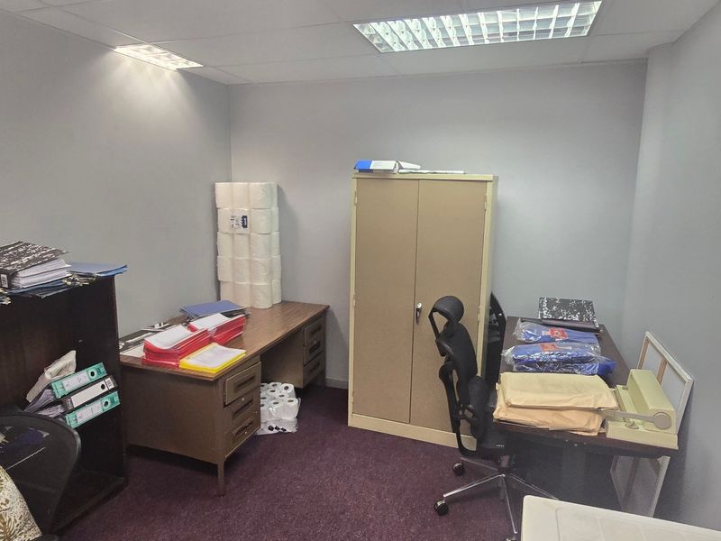 A functional commercial office space featuring a suspended ceiling with recessed lighting and carpeted flooring, suitable for administrative or professional use.
