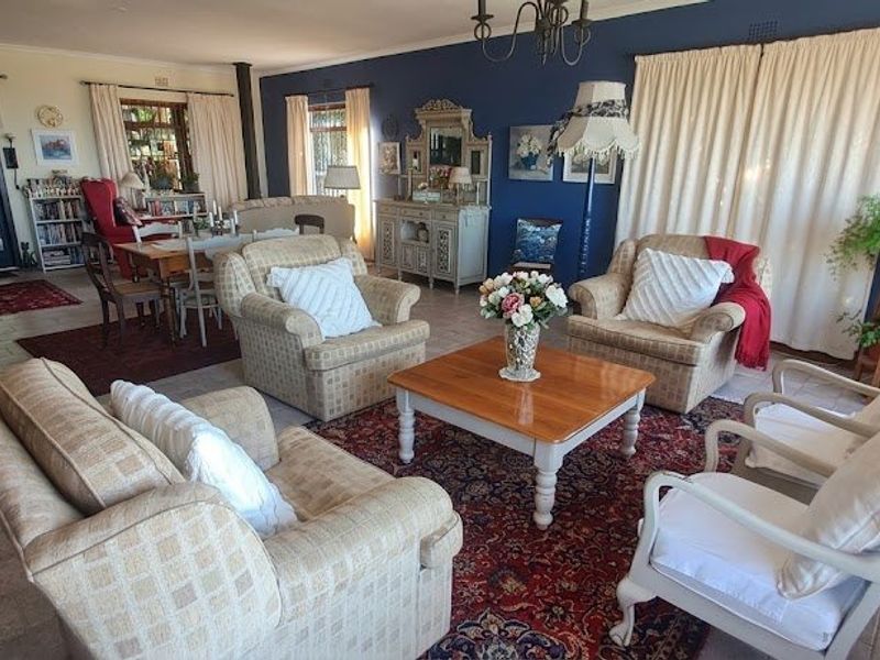 Spacious open-plan living and dining area featuring tiled floors, a fireplace, and direct access to an outdoor patio through double glass doors.